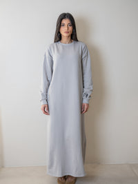 femme portant une robe pull oversize grise avec une poche zip