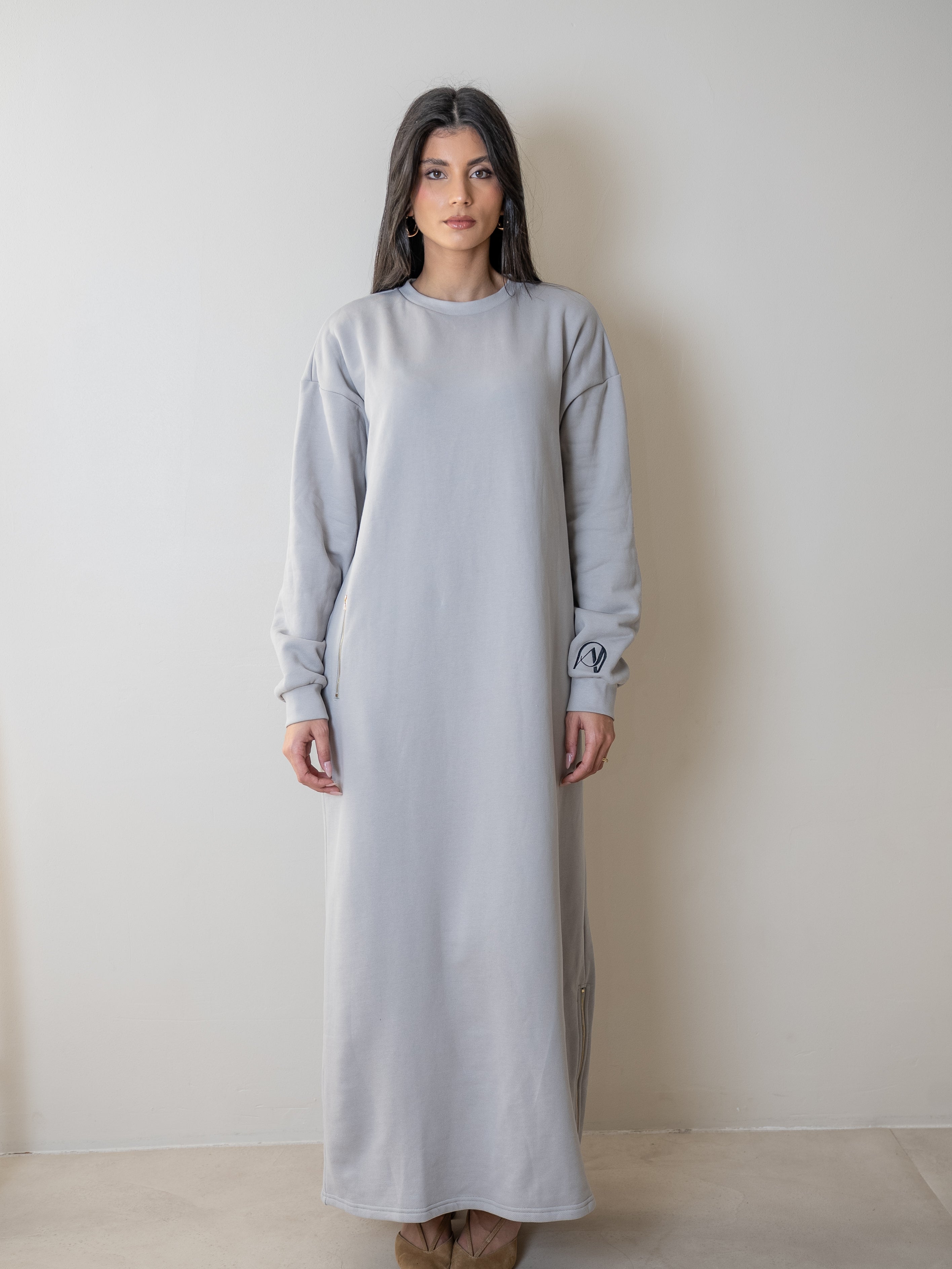 femme portant une robe pull oversize grise avec une poche zip