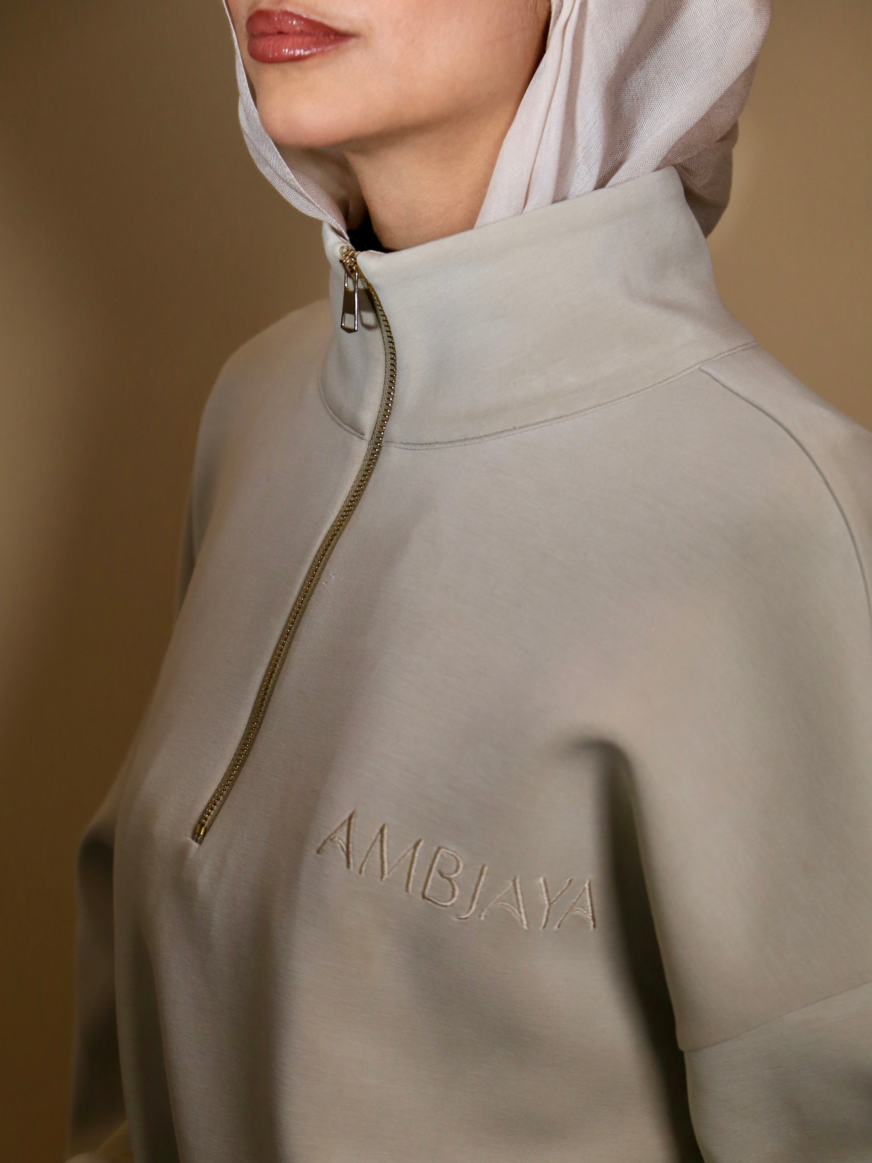 Ensemble Jogging Naya beige clair avec zip et logo discret, parfait pour allier style et confort.