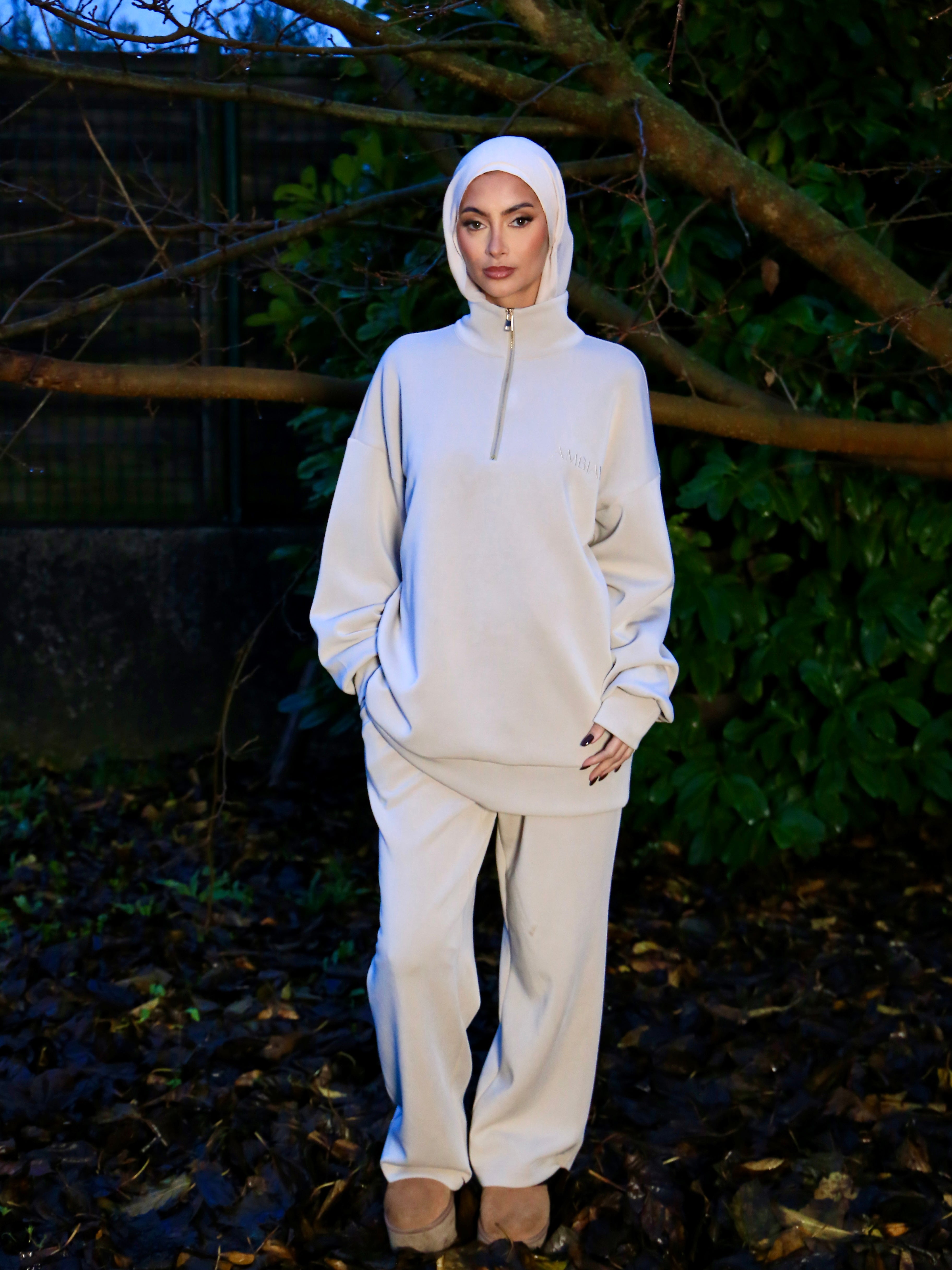 Femme portant l'Ensemble Jogging Naya Beige Clair, composé de TENCEL™, confort et style en extérieur.